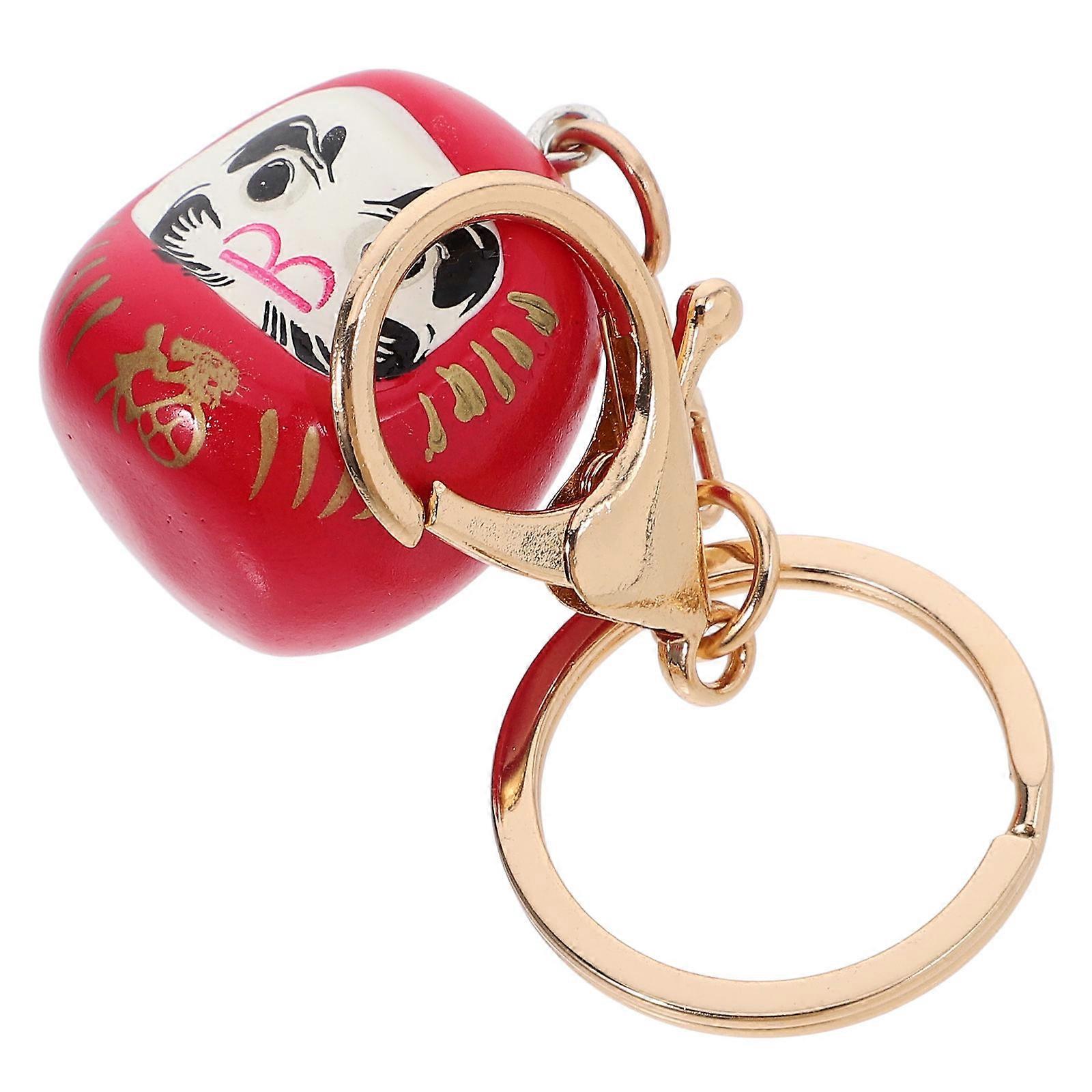 It sounds like you're describing a **Japanese Daruma doll keychain**—a small, decorative item often used as a **good luck charm**. Here's a refined