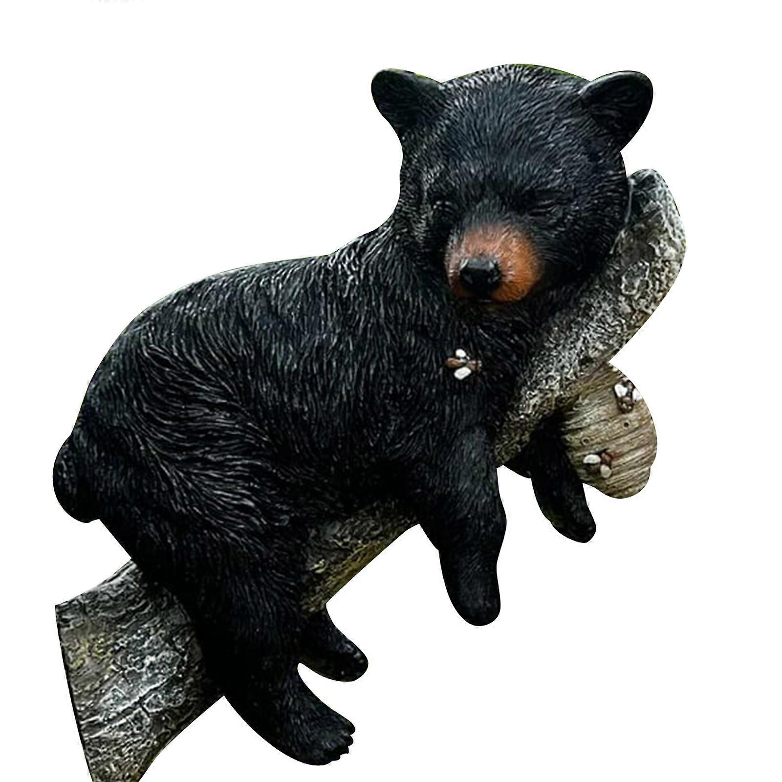 Black bear figurine napping in a tree