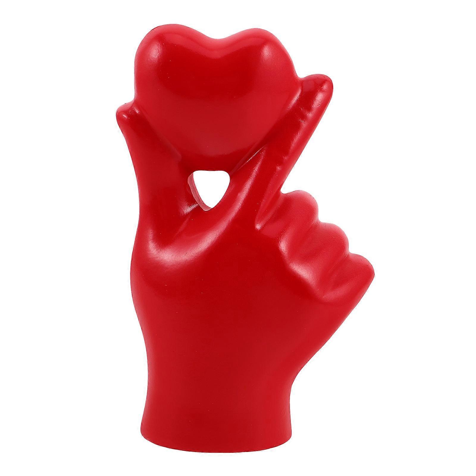 It sounds like you're describing a **resin based decorative sculpture** that features a **heart formed by hand gestures**, likely two hands shaping a