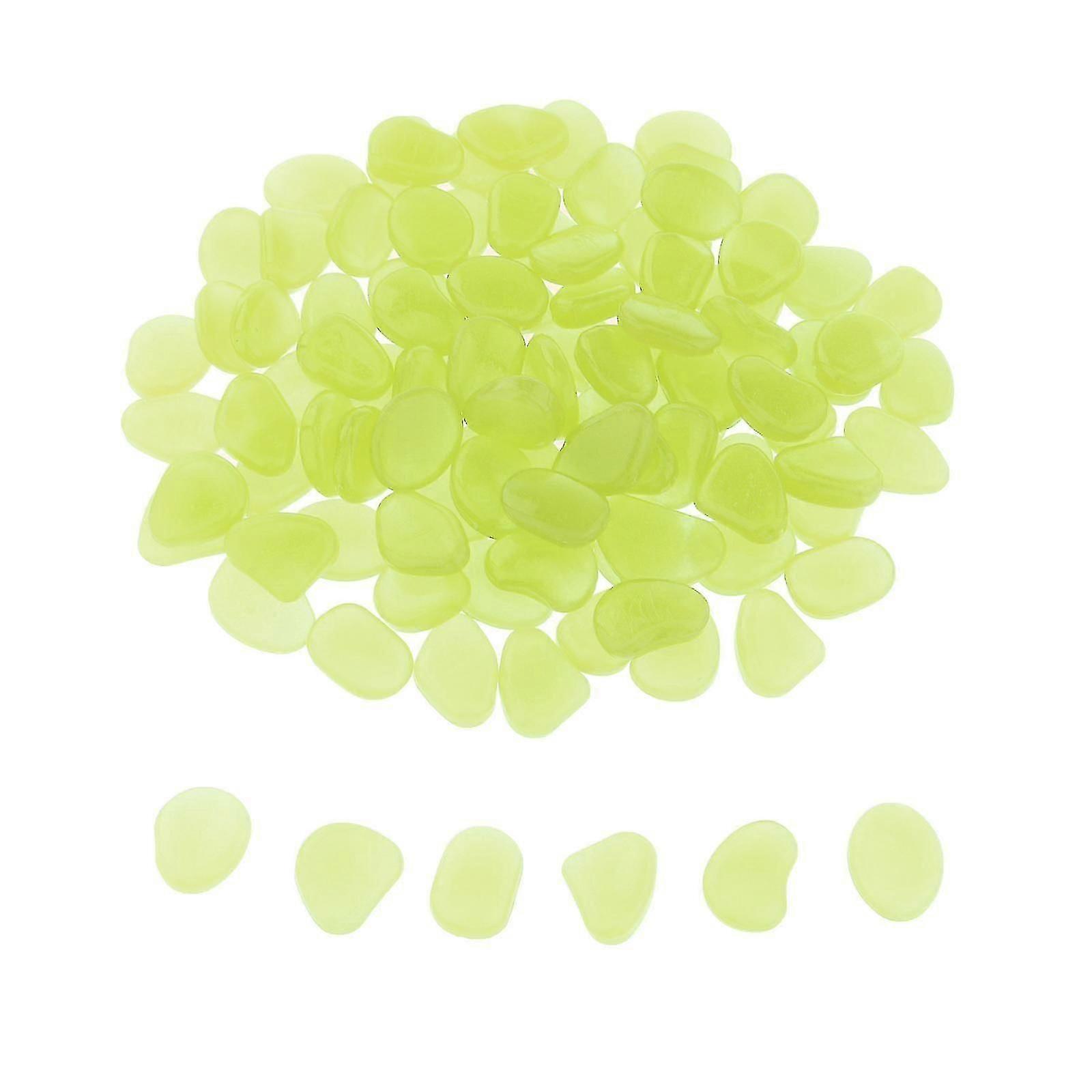 暗い庭の小石の石で光るパスヤードの装飾明るい黄色