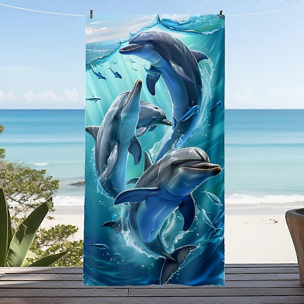 Oversized beach towel with brightly colored dolphin and fish designs perfect for beach vacations