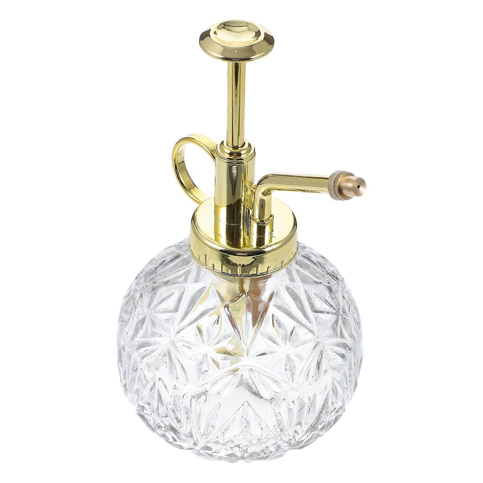 Vintage spray bottle transparent with golden watering can for plants in the garden and refillable stylish watering bottle