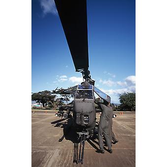 Air crewmen secure an AH-1 Cobra attack helicopter. Poster