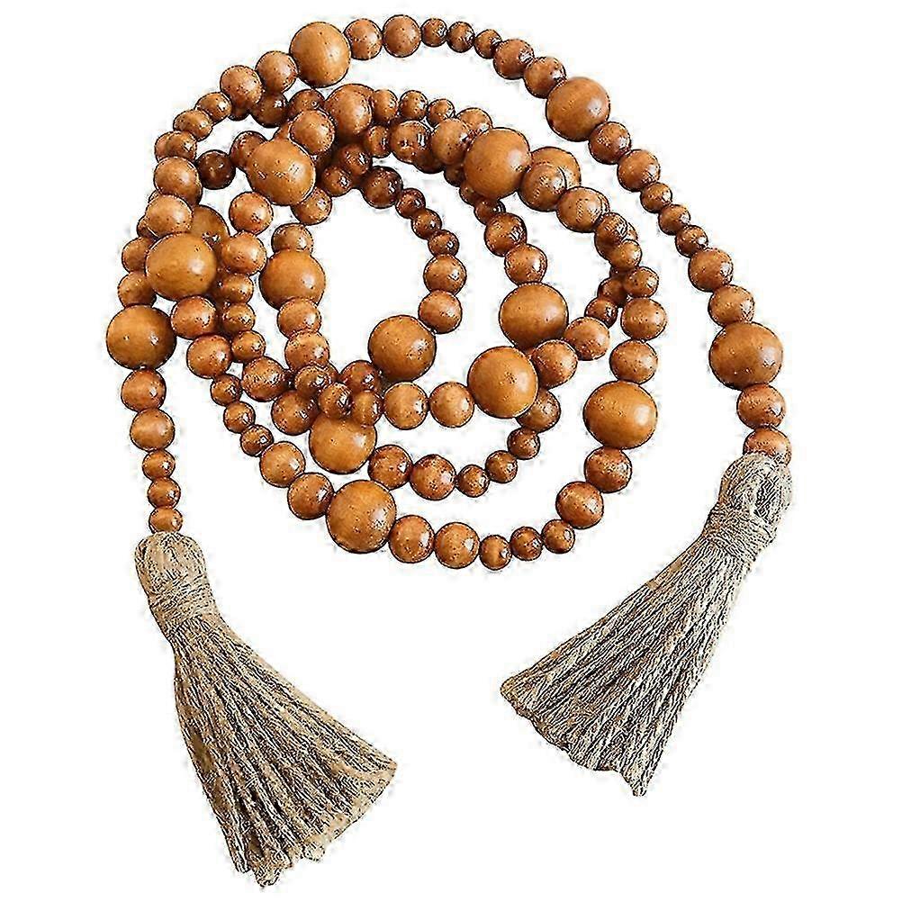 Maalaismainen puuhelmiseppele tupsuilla boho-seinäkoristeluun ja kodin muotoiluun