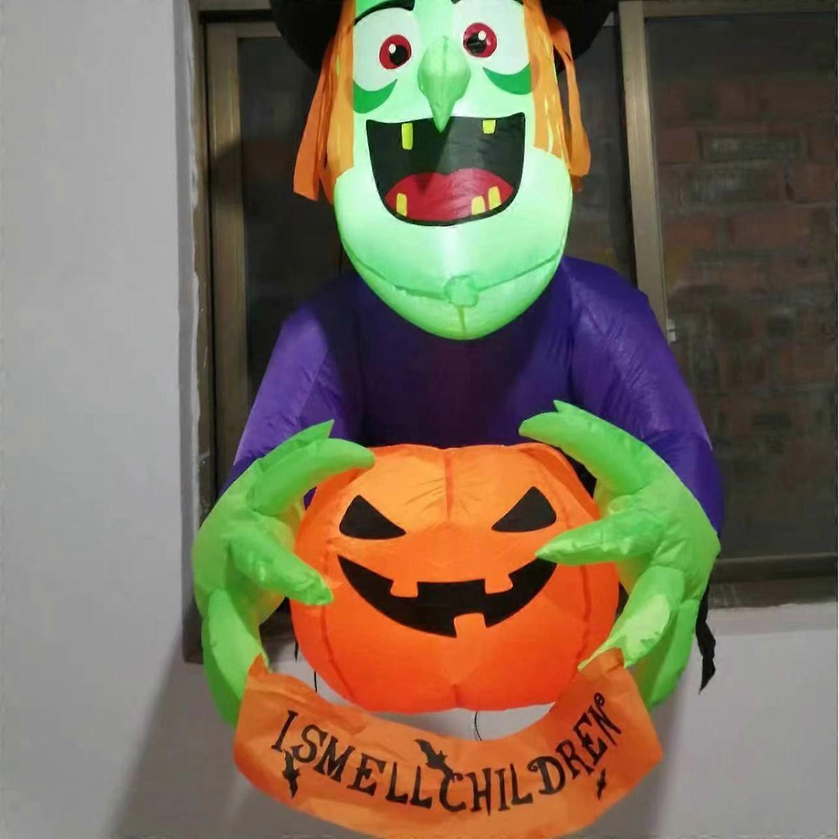 Inflatable witch climbing window holding pumpkin decoration