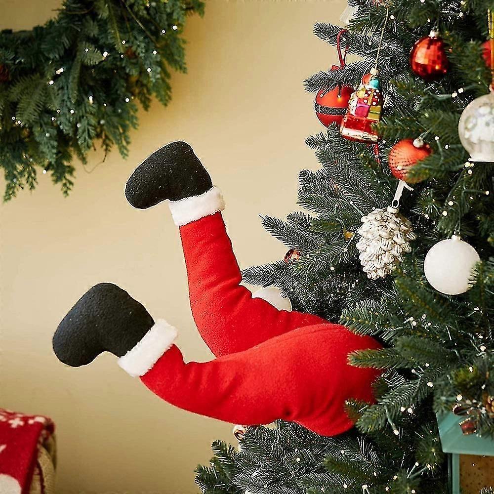 Jambes de Père Noël en peluche avec chaussures, coincées dans la décoration du sapin de Noël