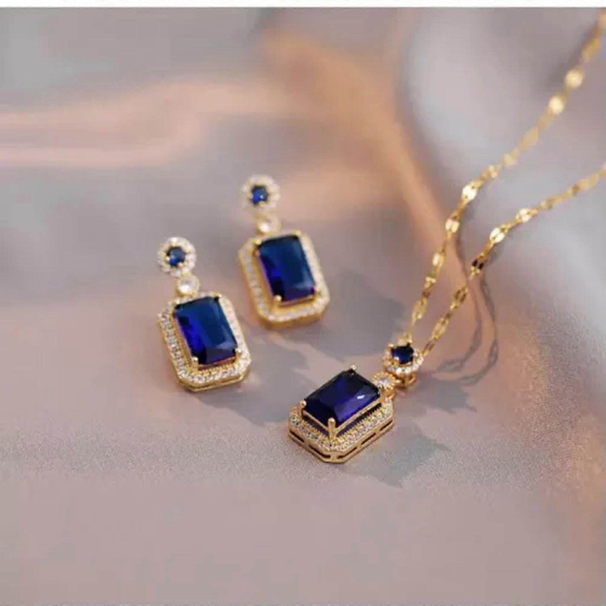 Elegant jewelry set with blue zircon in matte gold, for a wedding anniversary.