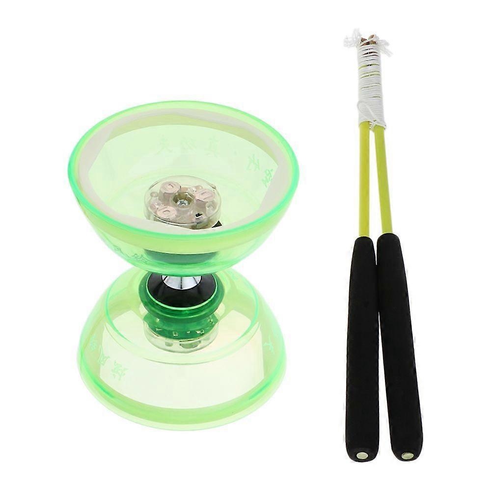 Diabolo juggling with three fires with sticks and green ropes